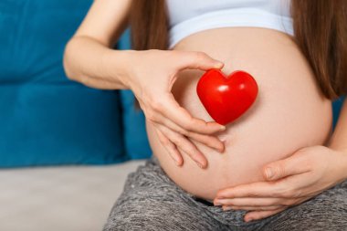 Karnında kalbi olan hamile bir kadın.