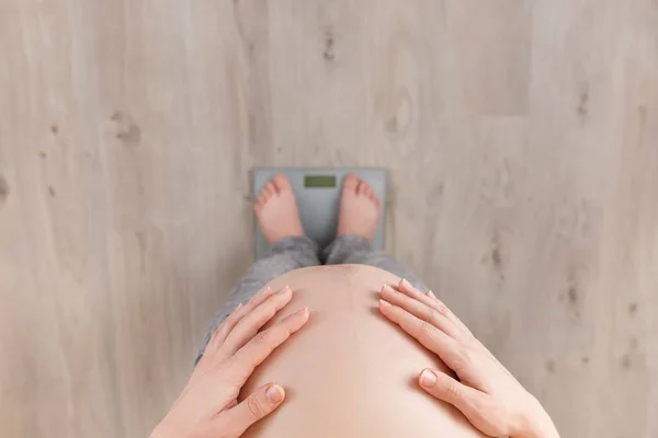Mujer embarazada de pie en escamas — Foto de Stock
