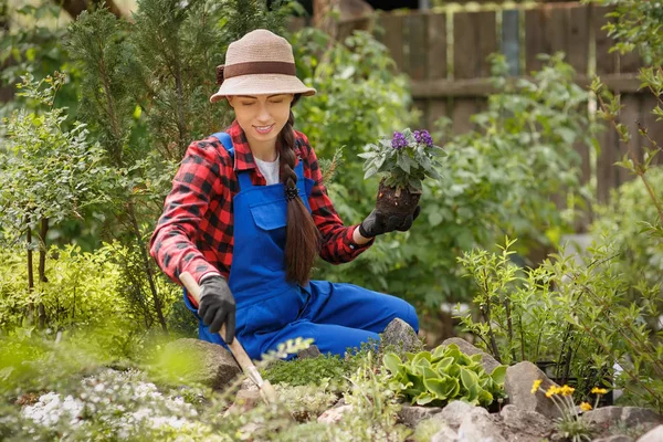 Donna giardiniere piantare fiori nel terreno — Foto Stock