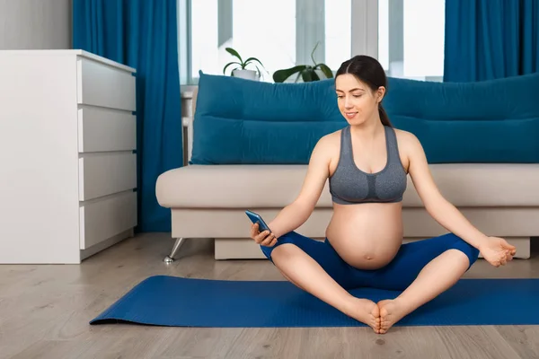 Mujer embarazada haciendo ejercicio de yoga — Foto de Stock