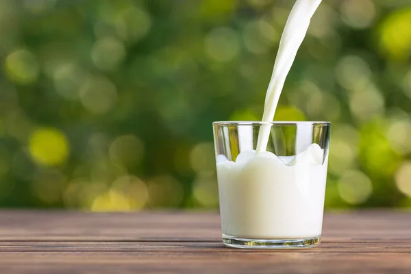 Melk die in glas wordt gegoten — Stockfoto