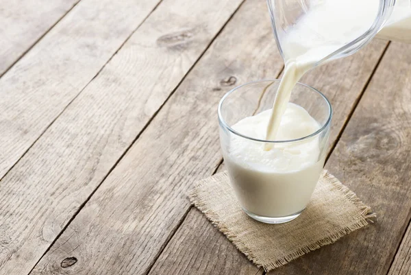 Melk die in glas wordt gegoten — Stockfoto