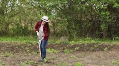 Çapalı genç kadın bahçıvan.