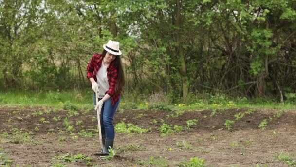 Mladá žena zahradník s motykou — Stock video