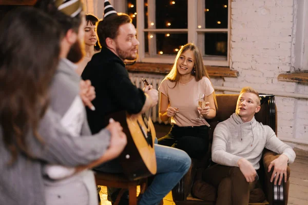 Happy young people are singing at the New Year party.