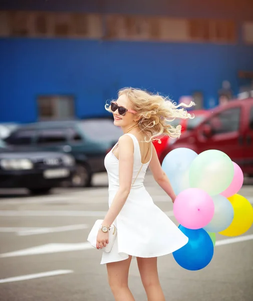 Hermosa rubia joven con un humor alegre Bailando en la calle con bolas de colores . —  Fotos de Stock