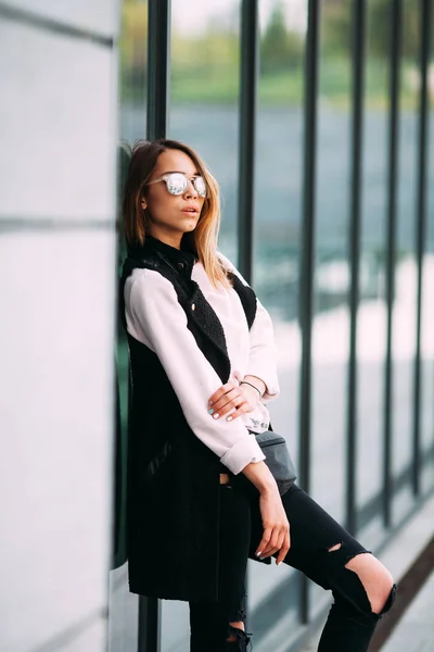 Concepto de moda callejera - mujer delgada bastante joven en estilo rock negro posando contra la pared —  Fotos de Stock