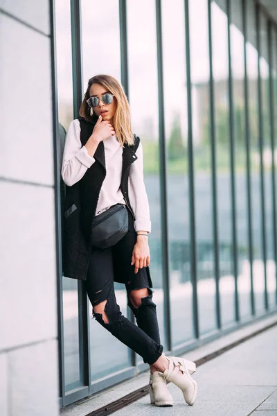 Concepto de moda callejera - mujer delgada bastante joven en estilo rock negro posando contra la pared — Foto de Stock