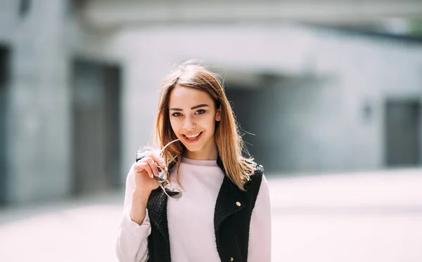 Moda yaşam tarzı gülen ve having fun sokakta güzel güneşli yaz gününde genç mutlu güzel kadın portresi