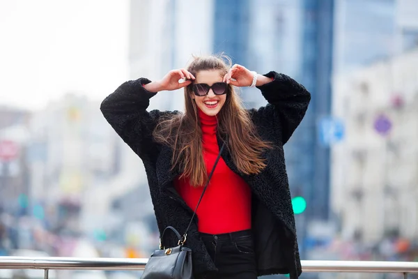 Utomhus livsstil närbild porträtt av glad ung kvinna i snygg casual outfit stående på gatan. — Stockfoto