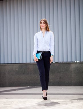 Açık yürürken başarılı iş kadını ile not etmek. Çalışan şehir iş kadın.