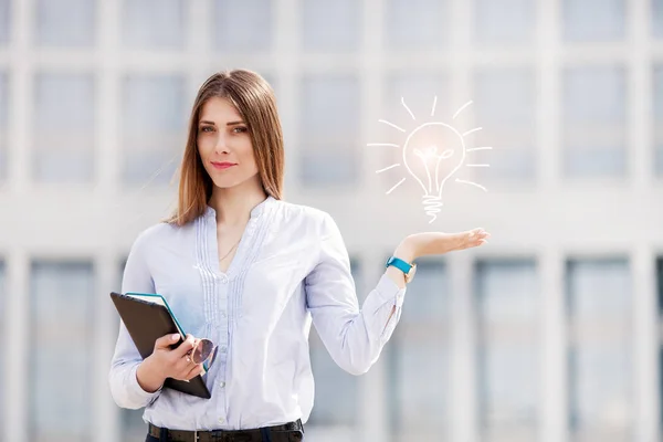 Ampul işareti fikri ile güzel bir iş kadını portresi. Yeni fikir