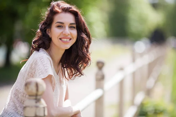 Portrait d'une jeune brune dans le parc. Belle fille charmante souriant . — Photo