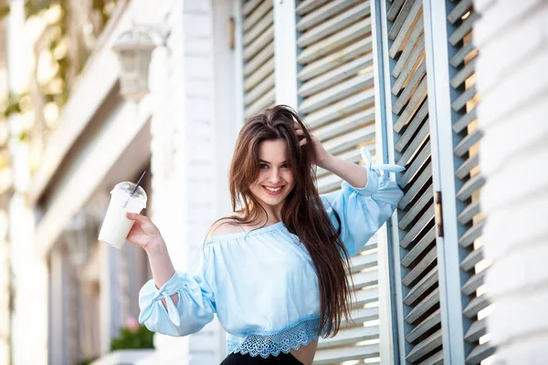 Portret mooi meisje met lange haren in een casual outfit poseren in het Italiaanse café. Mooie brunette houdt cocktail. — Stockfoto