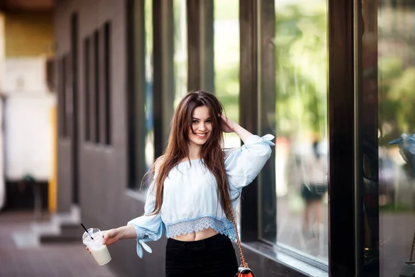 Retrato hermosa chica con el pelo largo en un traje casual paseos por la ciudad. Hermosa morena con café . — Foto de Stock