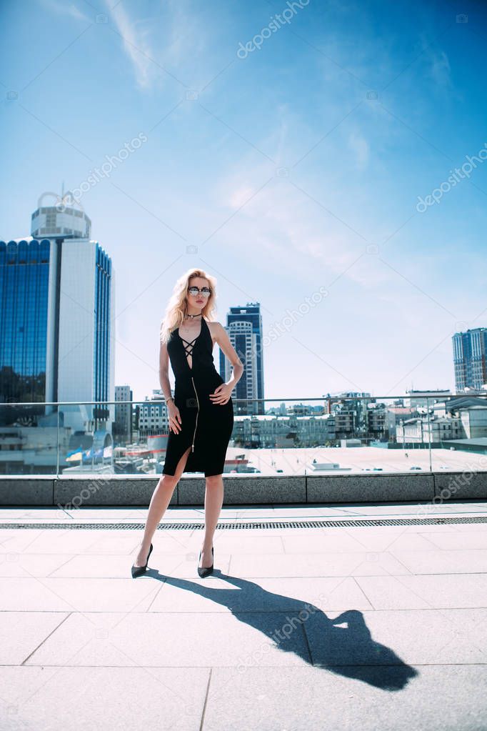 Outdoor full body portrait of a young beautiful fashionable woman posing on the street. Model looking at camera. Lady wearing stylish clothes. Female fashion concept. City lifestyle