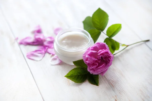 Organic cosmetic with rose and pot of moisturizing face cream on white background — Stock Photo, Image