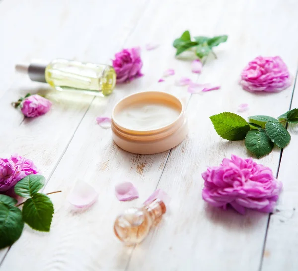 Cosmética orgánica con aceite de rosa y crema de belleza sobre fondo blanco —  Fotos de Stock