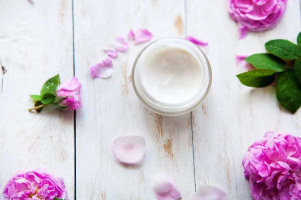 Natural cosmetic cream skincare product wellness and relaxation surrounded by rose blossom on white wooden table — Stock Photo, Image