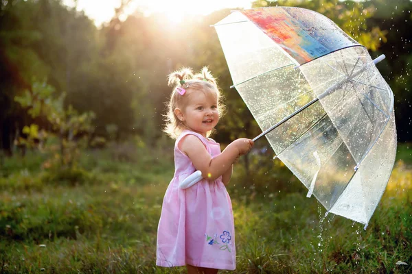 Menina engraçada feliz curtindo a chuva Menina pequena bonito de pé sobre a natureza ao ar livre Fechar retrato de Menina bonita sob guarda-chuva no parque — Fotografia de Stock