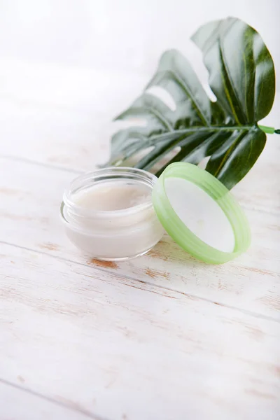 Crema facial y monstruos sobre un fondo de madera blanca. cosmética orgánica natural facial — Foto de Stock