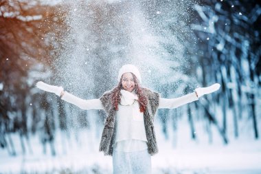 Kız parkta karla oynuyor