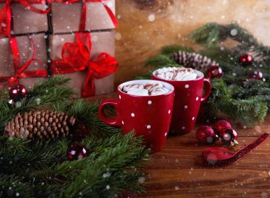 Koyu ahşap zemin üzerinde marshmelow ile Noel sıcak çikolatası, Noel ağacı dalları süsleme.