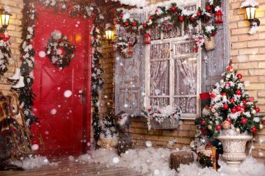 Bir veranda üzerinde Noel dekor. Kapılar şenlikli bir çelenk ve oyuncaklar tarafından dekore edilmiştir. Bir pencere, köknar ağacı