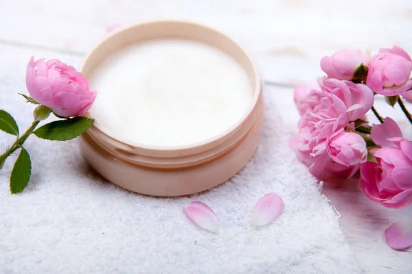 Spa konseptiyle nemlendirici krem ve güzel pembe güller tencere. Kaplıca tedavisi.