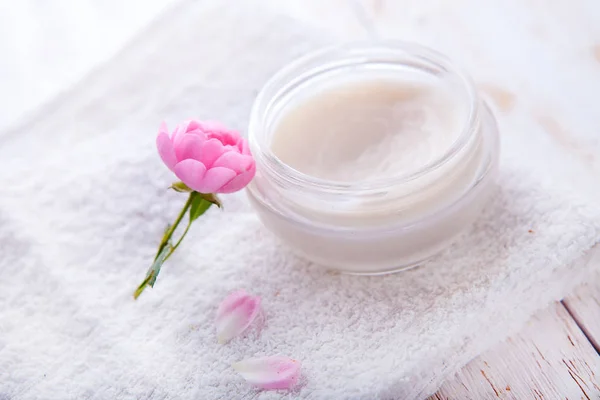 Spa setting with pot of moisturizing cream beautiful pink roses and rose oil on white background top view — Stock Photo, Image