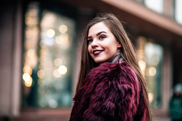 Ung vacker modell flicka ler och ser tillbaka i staden. Dynamiskt ung flicka går längs gatan.Hår fladdrar i vinden. — Stockfoto