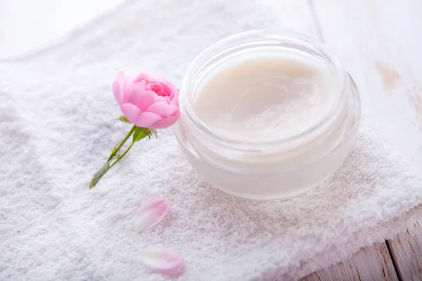 Cosmética orgánica con rosa y olla de crema hidratante para la cara sobre fondo blanco vista superior —  Fotos de Stock