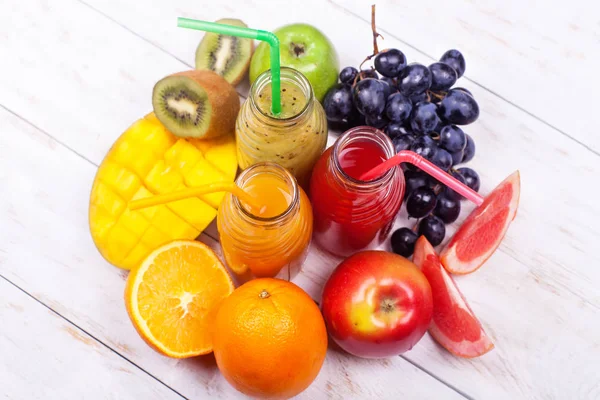 新鮮なジュース スムージー ボトル レッド グリーン オレンジ熱帯果物水メロン アップル キウイ ブドウ オレンジ — ストック写真