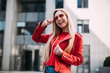 Uzun açık renk saçlı, süper mutlu bir kadının yaz portresi. Parlak moda güneş gözlükleri, parlak seksi makyaj, seyahat havası.