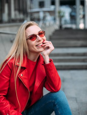 Kırmızı deri ceketli güzel kız kameraya bakıyor..