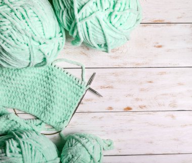 Ahşap bir arka planda yün ve örgü iğneleri..