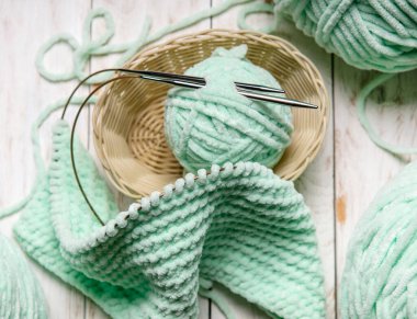 Ev hobileri, ahşap bir arka planda, oturma odasında iplik yumağıyla örülmüş rahat bir ekose.