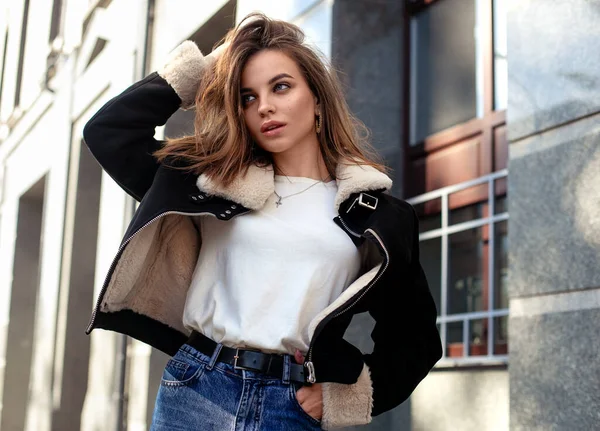 Moda sokak stil portresi kapanıyor. Güz kıyafetleri içinde güzel esmer kız açık havada poz veriyor.