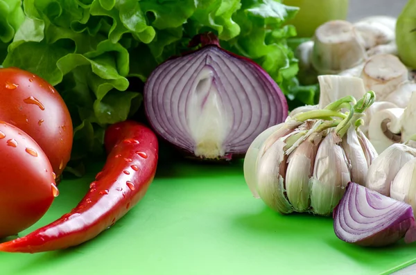 Sayuran, jamur dan daun salad di papan tulis dapur — Stok Foto