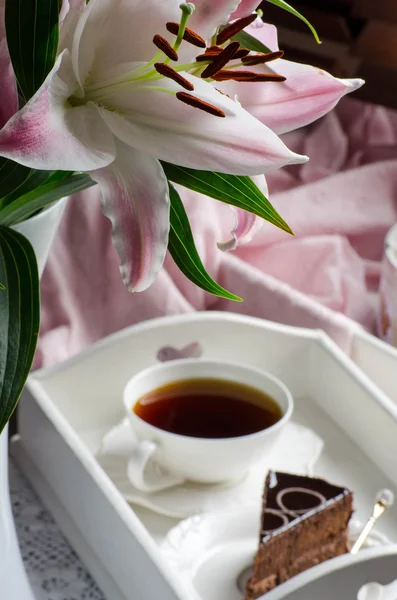 Bodegón con lirios, té y postres en tonos rosados . — Foto de Stock