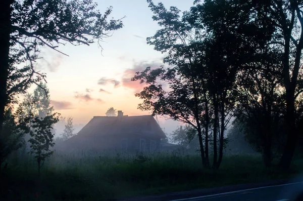 Zmierzch. Dom we mgle nad drogą. — Zdjęcie stockowe