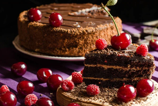 Süßigkeiten und Desserts. Schokoladenkuchen mit Kirschen und Himbeeren — Stockfoto