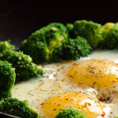 Brokoli ve baharat bir tavada ile pişmiş yumurta