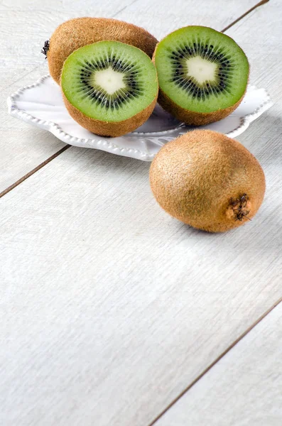 Fructele kiwi de pe masă pe o placă albă — Fotografie, imagine de stoc