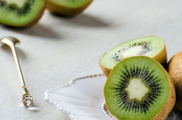 Fructele kiwi pe o farfurie albă și lingură de desert — Fotografie, imagine de stoc