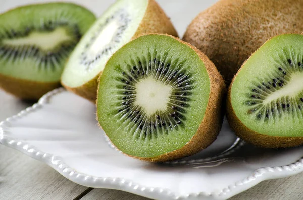 Fructele kiwi de pe masă pe o placă albă — Fotografie, imagine de stoc