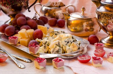 Peynir ve gümüş bir tepside üzüm.