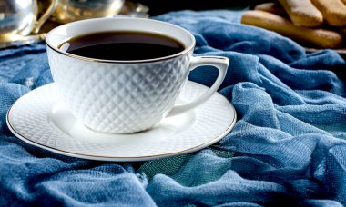 Beyaz bir fincan çay. Karanlık bir fotoğraf.