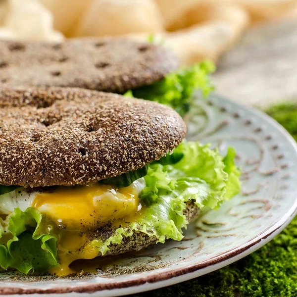 Healthy food - sandwiches of dark bread and poached eggs.