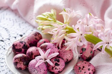 Paskalya yumurta beyaz bir tabak ve sümbül çiçekleri.